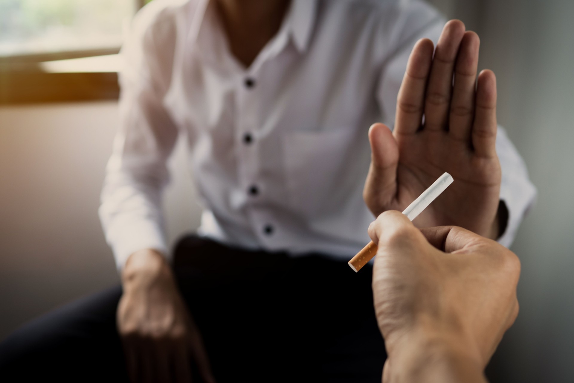 Cropped Hand Of Person Giving Cigarette To Man