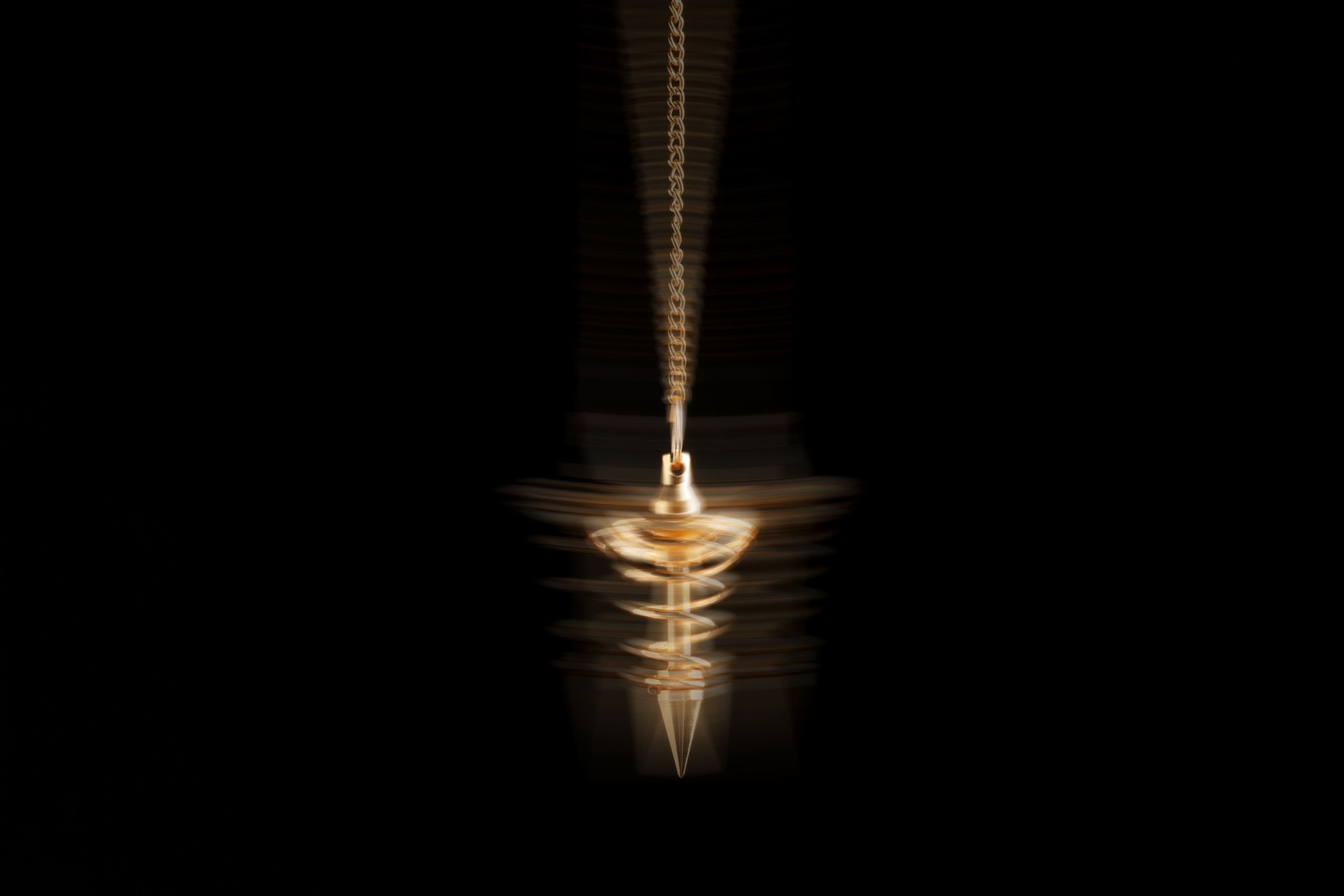 Hypnosis session. Golden pendulum swinging on black background, motion blur effect Hypnosis session. Golden pendulum swinging on black background, motion blur effect